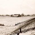 Nwe Statenzijl -18  De boerderij van Eggo Hillinga met daarachter de woningen van Nieuwe Statenzijl langs de Westerwoldse Aa. Op de boerderij langs de grens met Duitsland woonden tot 1941 Johannes van der Kamp en zijn vrouw Elisabeth Siemens, geboren in 1882, en hun zeven kinderen. Daarna vertrokken ze naar Drieborg en nam, Harm Hillinga sr. (1894-1958), getrouwd met Hebelbiena Hulsing (1897-1973) de boerderij over. Zij kregen twee kinderen, Eggo (1920-1977) en Harmanna Gesina (Manne, geb. 1919). In mei 1945 werd de boerderij gebombardeerd en onbewoonbaar. Zoon Eggo Hillinga, getrouwd met Geertje de Vries (geb. 1924), nam in mei 1957 de boerderij over. Zij verlieten in 1965 samen met hun zoon Harm (geb. 1947), Nieuwe Statenzijl, omdat op het land waarop de boerderij stond, een dijk werd aangelegd en de boerderij moest worden afgebroken. De boerderij is altijd eigendom van de Stad geweest en werd gepacht. (Foto: Harm Hillinga, 1969).